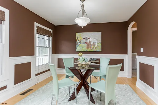 a bedroom with a large bed couch and two windows