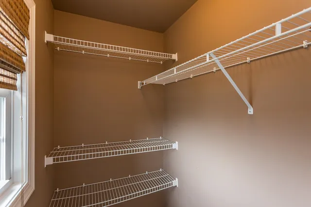 a view of a hallway with windows and chandelier