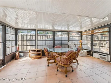 a dining room with furniture and large windows