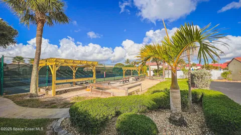 a view of a house with a yard and palm trees