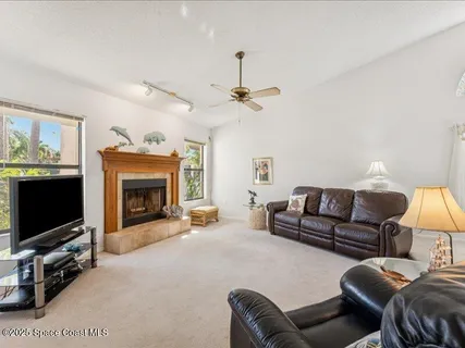 a living room with furniture a flat screen tv and a fireplace