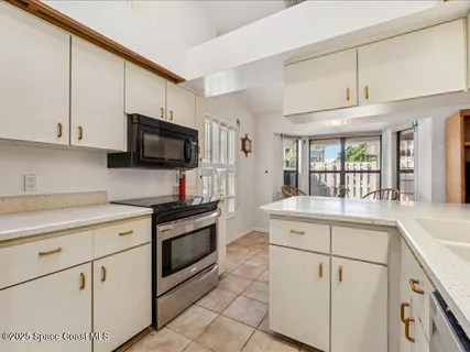 a kitchen with granite countertop white cabinets and white appliances