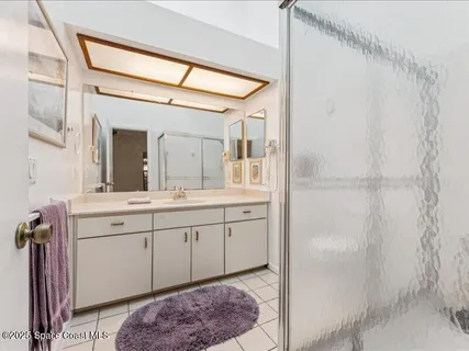 a spacious bathroom with a double vanity sink a mirror and a shower