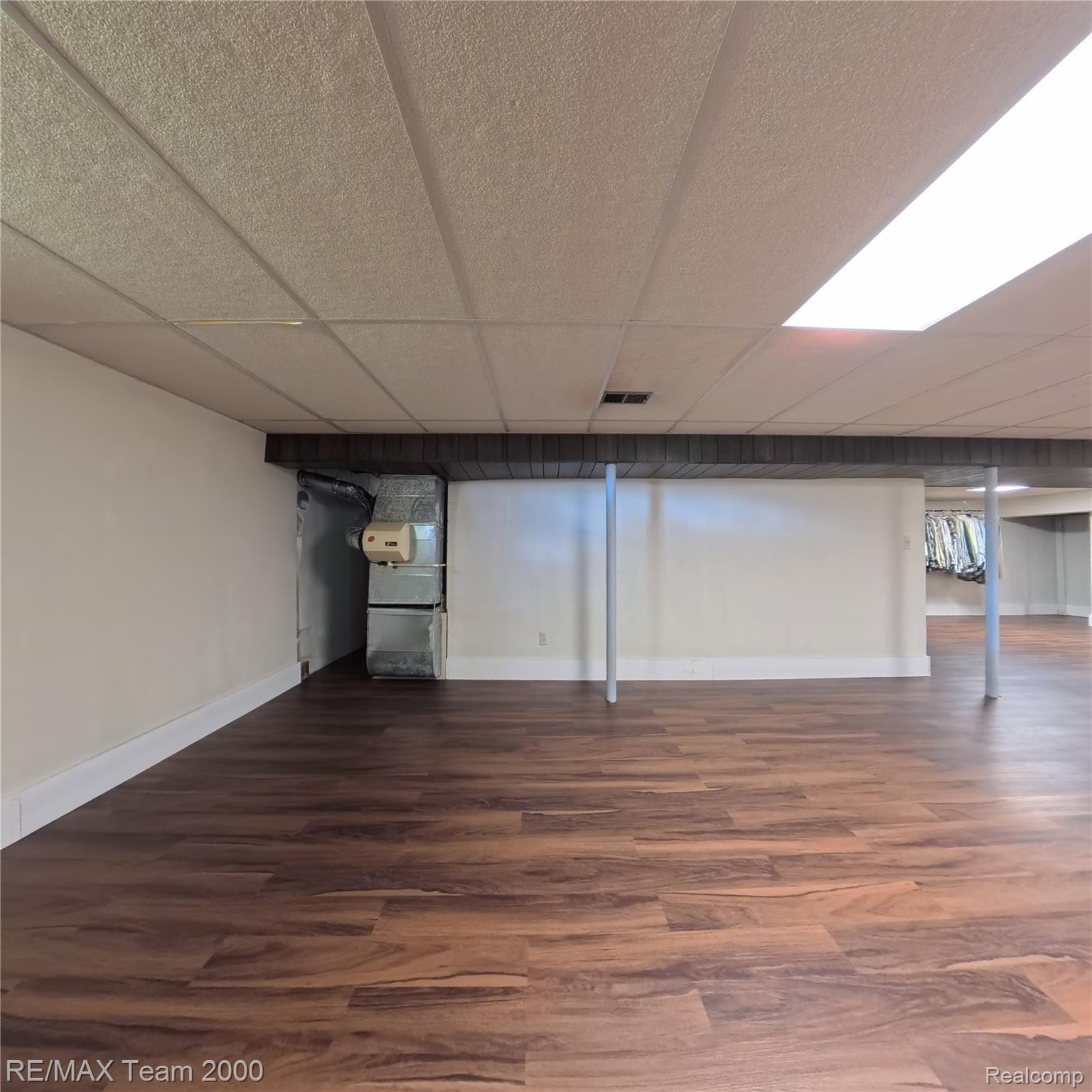 2104 Whittier Road Ypsilanti, MI 48197 - Photo 31 of 45 Finished below grade area featuring dark wood-style floors, a paneled ceiling, and heating unit