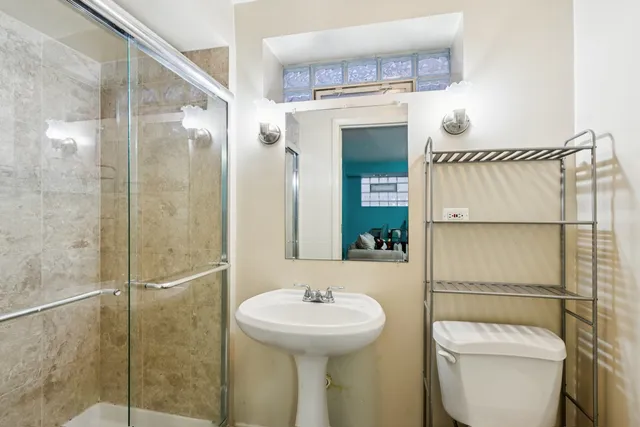 a bathroom with a sink a toilet and shower