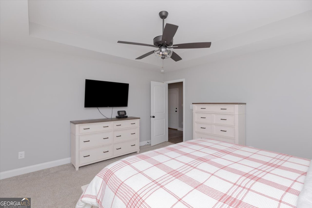 104 Meredith Layne Court Perry, GA 31069 - Photo 24 of 46 a bedroom with a bed and a flat screen tv
