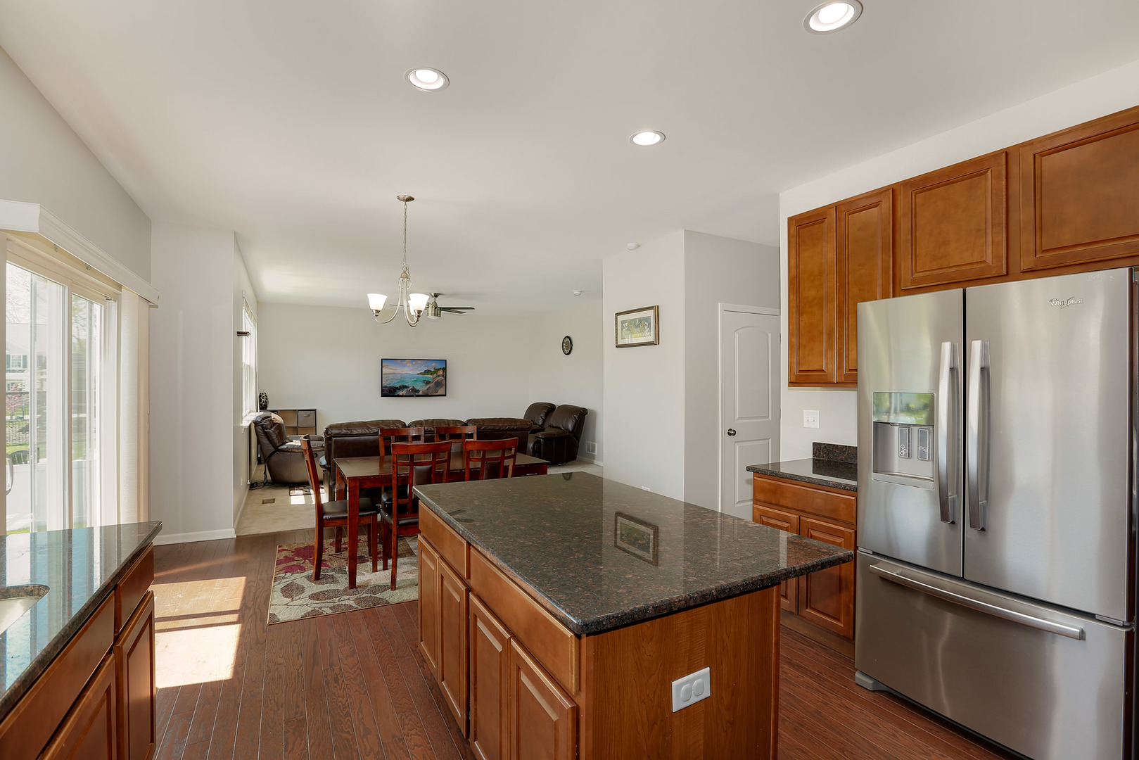 3531 English Prairie Road Elgin, IL 60124 - Photo 9 of 34 a kitchen with a refrigerator a kitchen island a stove and a dining table with wooden floor