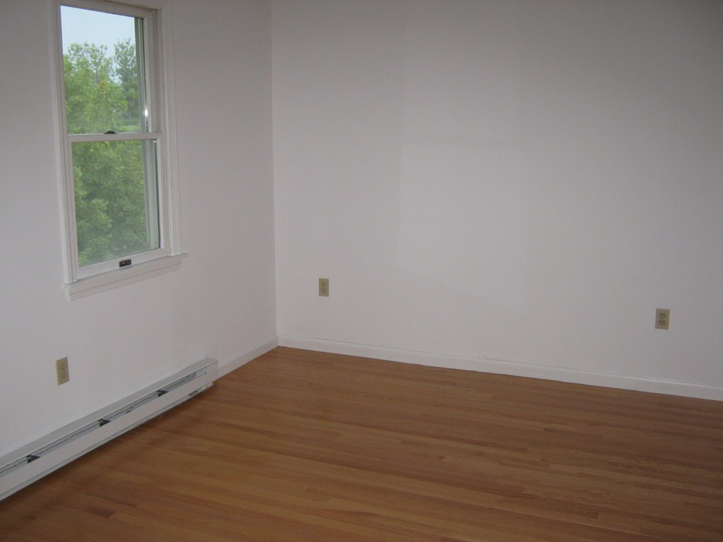 65 Victoria Heights Road, Unit 65 Boston, MA 02136 - Photo 11 of 16 a view of an empty room with wooden floor and windows