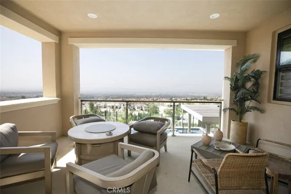 a view of a patio with table and chairs potted plants with floor to ceiling window
