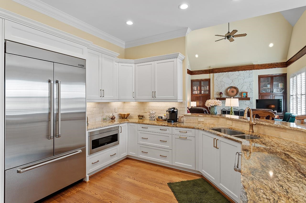 1116 Hunting Ridge Road Raleigh, NC 27615 - Photo 35 of 91 a kitchen with granite countertop a refrigerator a sink a stove and cabinets