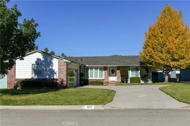 a front view of a house with a yard and trees