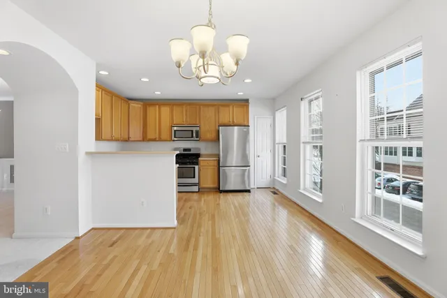 a view of a kitchen with wooden floor and a window