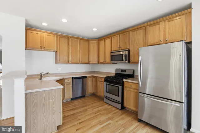 a kitchen with wooden cabinets and stainless steel appliances