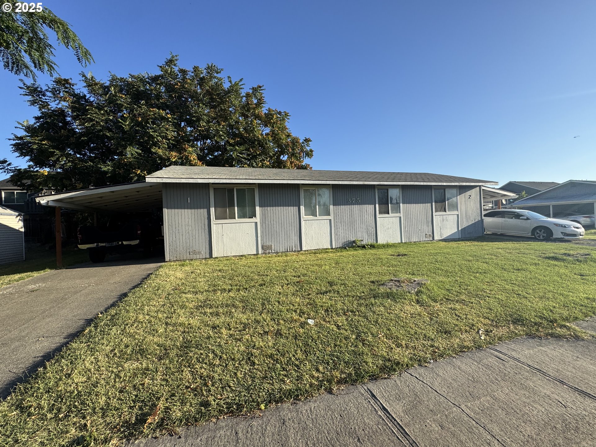 375 East Cherry Avenue Hermiston, OR 97838 - Photo 1 of 1 a front view of house with yard and trees in the background