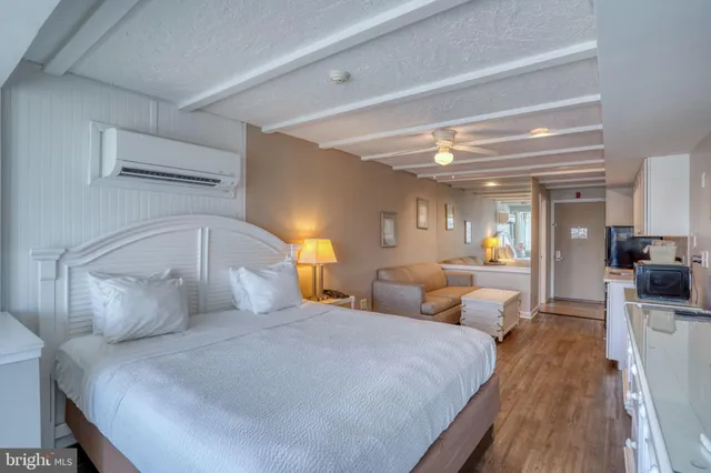 a bedroom with a bed and a view of living room