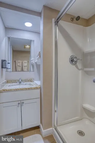 a bathroom with a granite countertop sink a toilet mirror and vanity