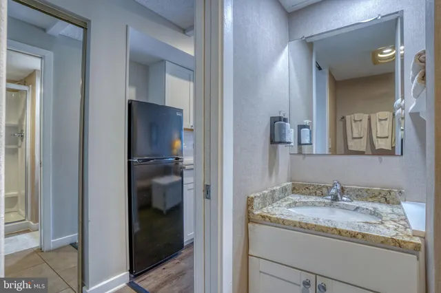 a en suite bathroom with a granite countertop sink and a mirror