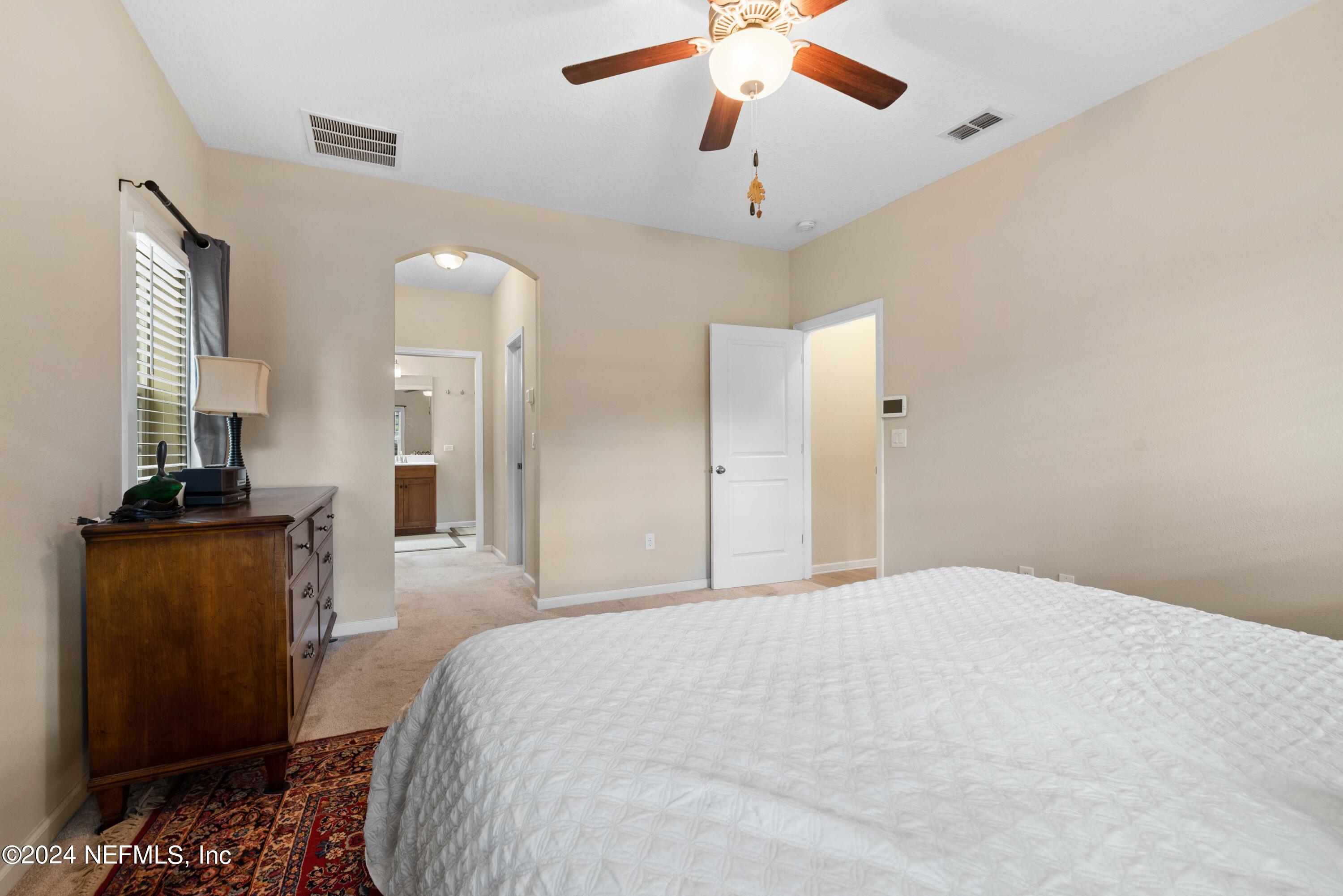 245 Floco Avenue Yulee, FL 32097 - Photo 15 of 38 a spacious bedroom with a bed and a chandelier