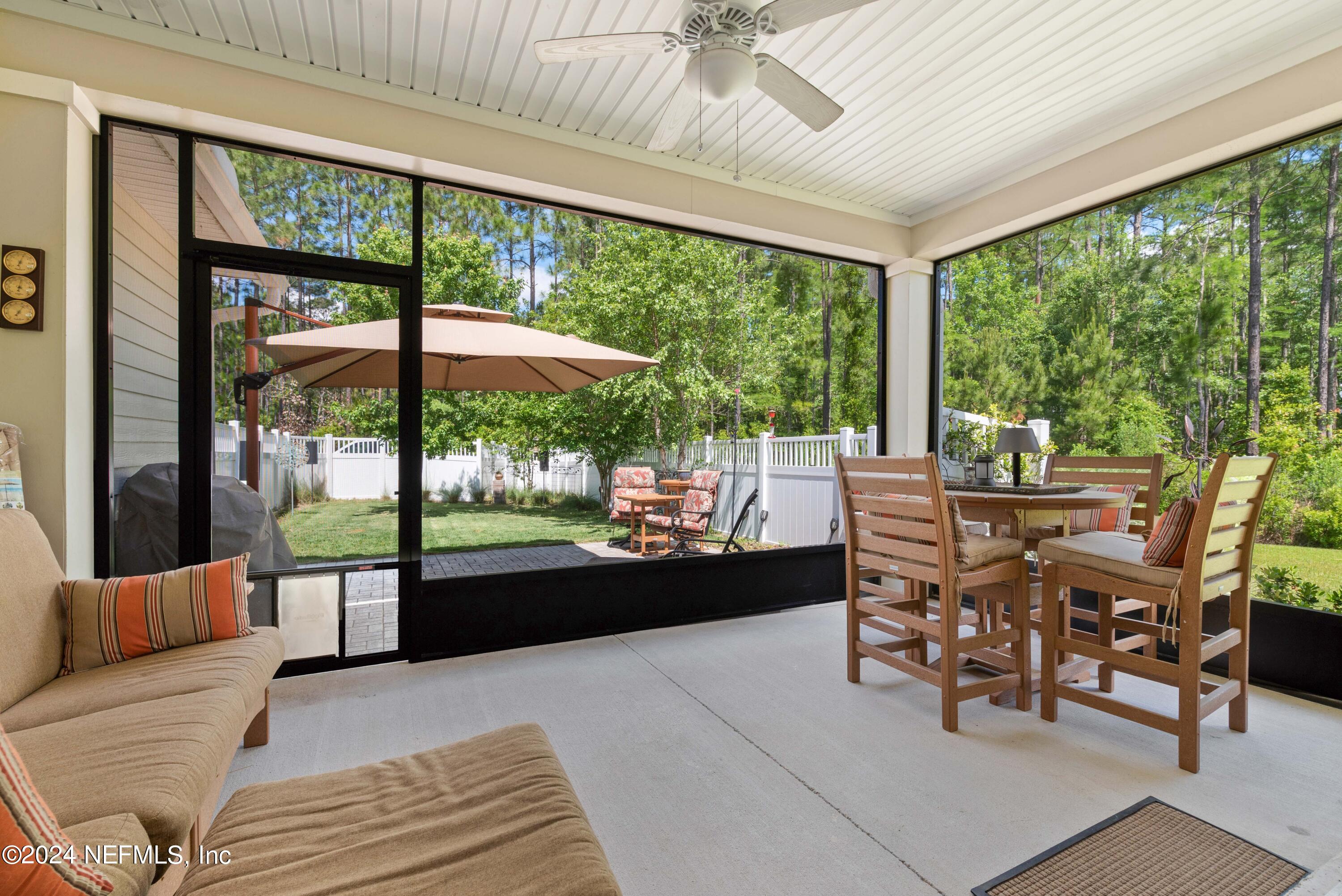 245 Floco Avenue Yulee, FL 32097 - Photo 24 of 38 a view of a dining room with furniture large windows and wooden floor