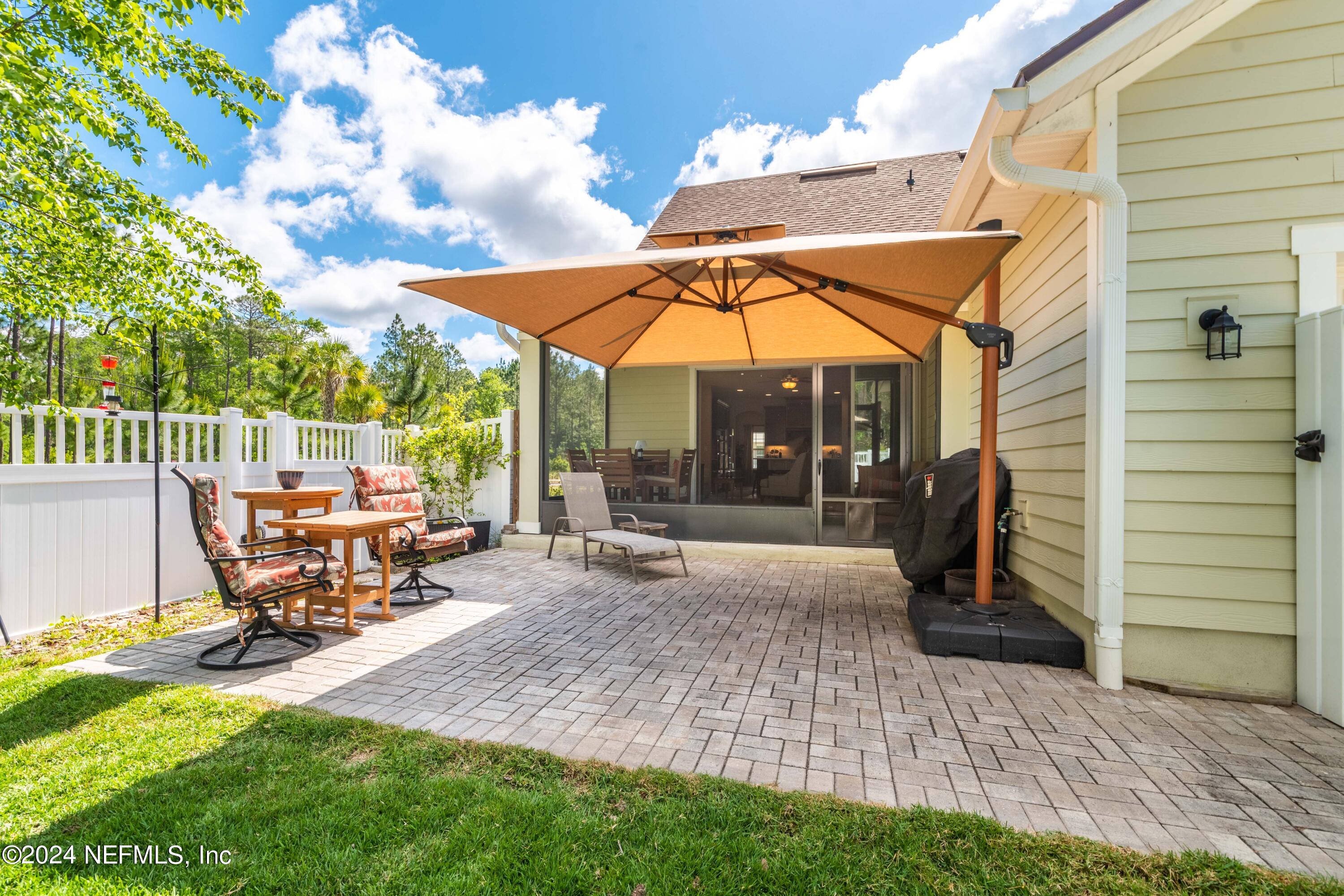 245 Floco Avenue Yulee, FL 32097 - Photo 25 of 38 a view of a patio with a table and chairs under an umbrella