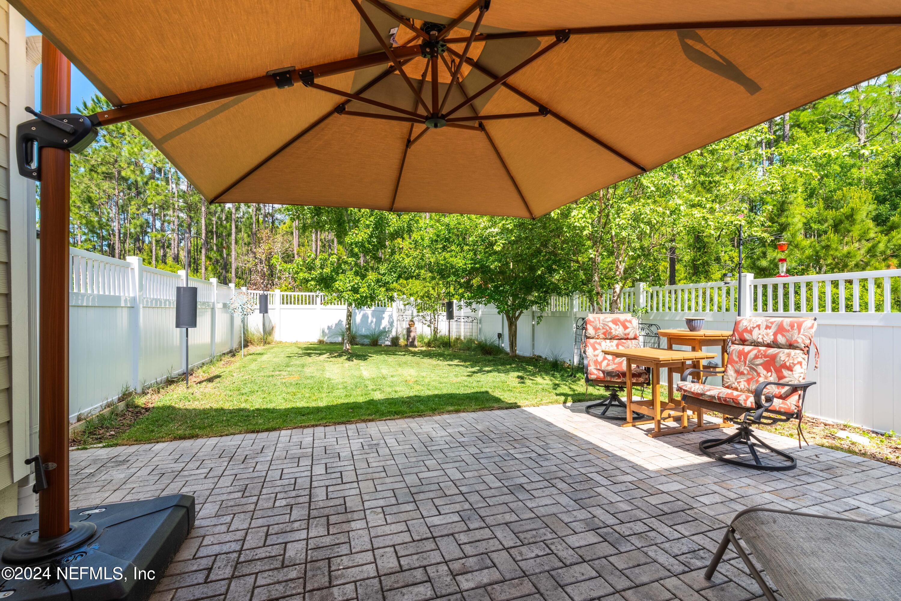 245 Floco Avenue Yulee, FL 32097 - Photo 26 of 38 a view of backyard with table and chairs under an umbrella