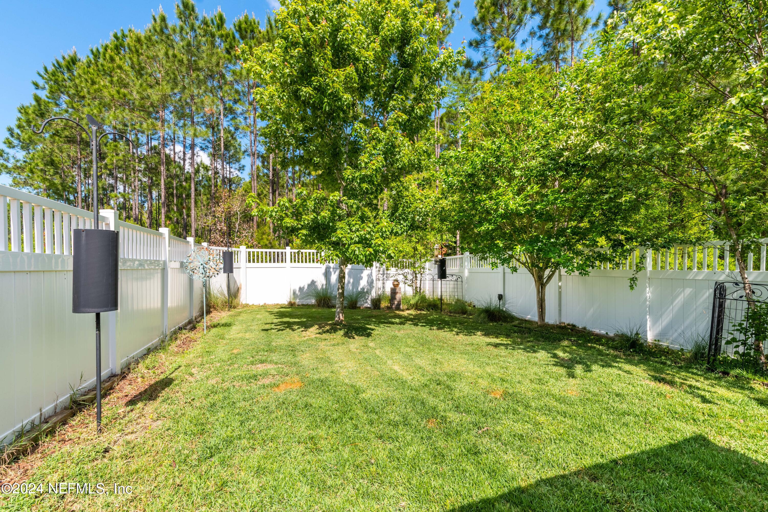 245 Floco Avenue Yulee, FL 32097 - Photo 30 of 38 a backyard of a house with plants and large trees