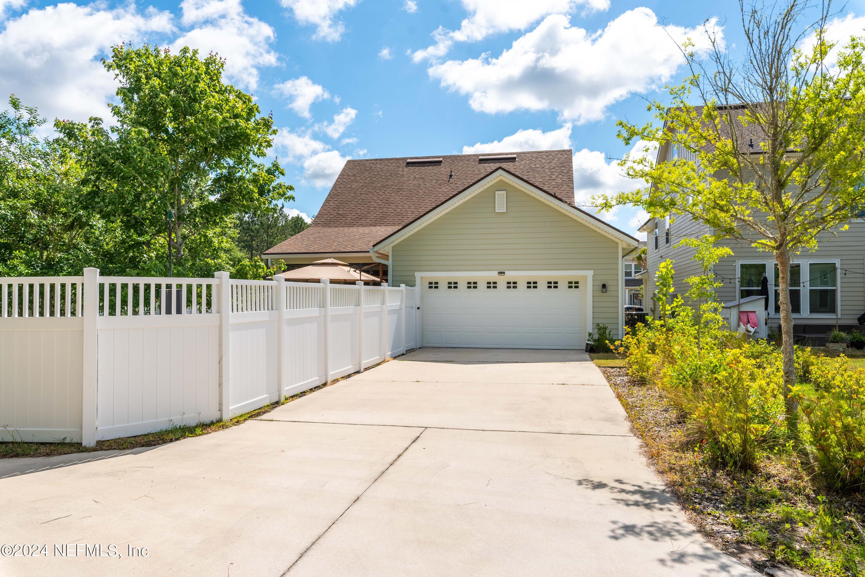 245 Floco Avenue Yulee, FL 32097 - Photo 31 of 38 a view of a house with a small yard and a large tree