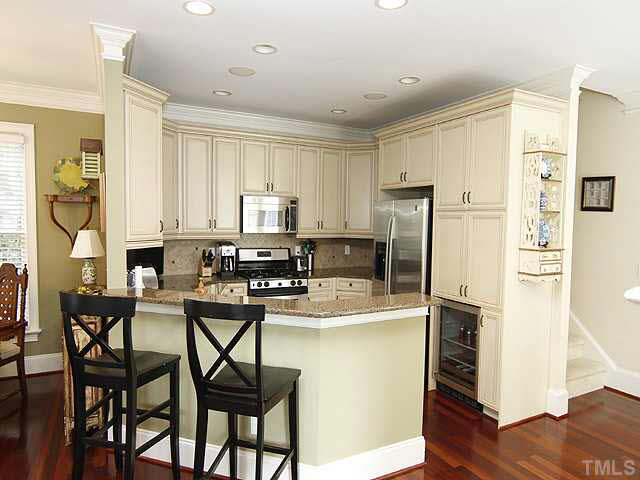 1710 Center Road Raleigh, NC 27608 - Photo 4 of 12 a kitchen with stainless steel appliances granite countertop a refrigerator a stove a sink and white cabinets with wooden floor
