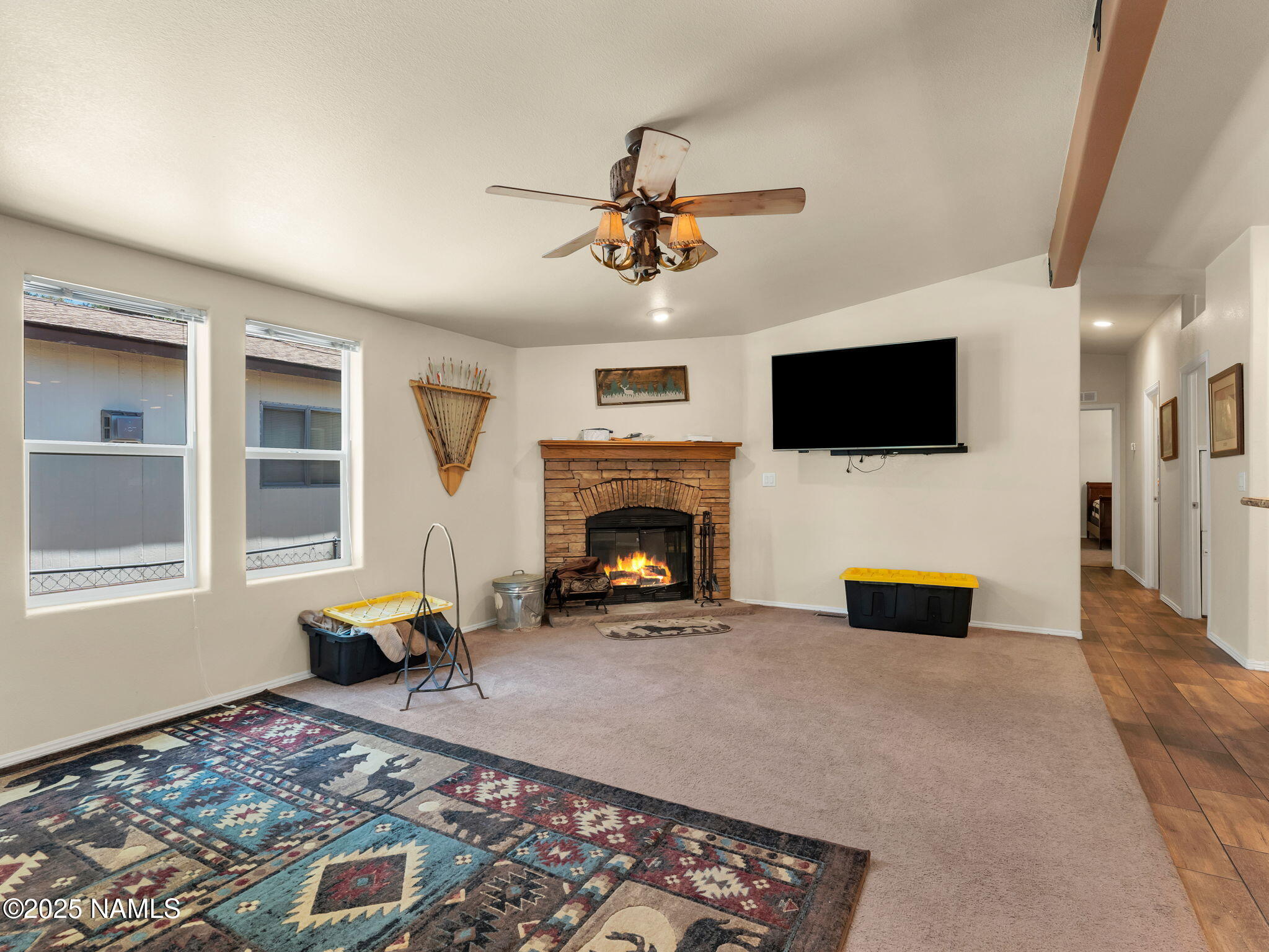 1151 Caribou Road Munds Park, AZ 86017 - Photo 17 of 30 a living room with furniture a flat screen tv and a fireplace