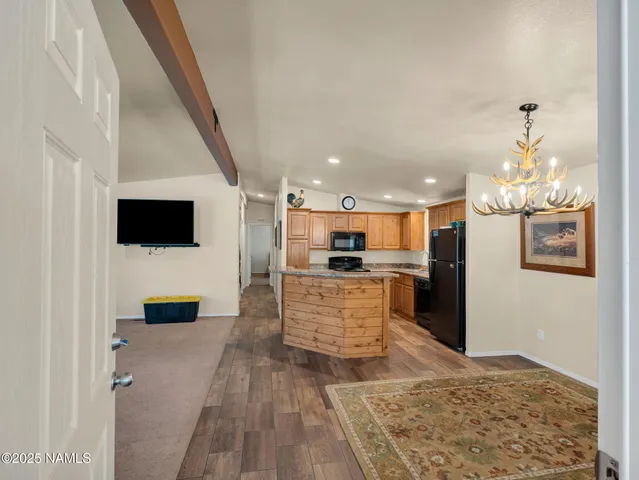 a living room with stainless steel appliances kitchen island granite countertop furniture a rug and a view of kitchen