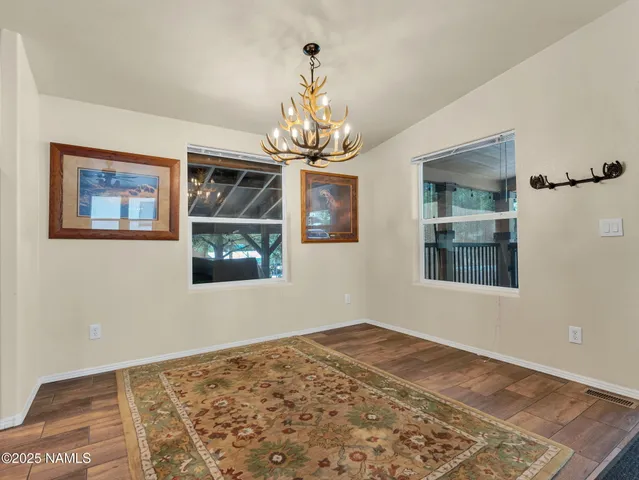 a view of a bedroom with wooden floor and windows
