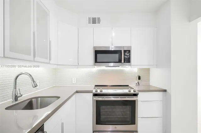 a kitchen with stainless steel appliances a sink stove and refrigerator