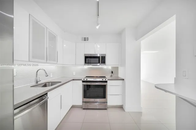 a kitchen with stainless steel appliances granite countertop a refrigerator and a sink