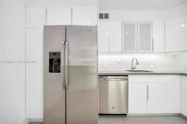 a view of kitchen with a sink and refrigerator