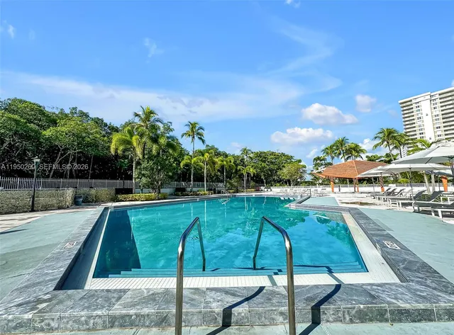 a view of a swimming pool with a table and chairs under an umbrella