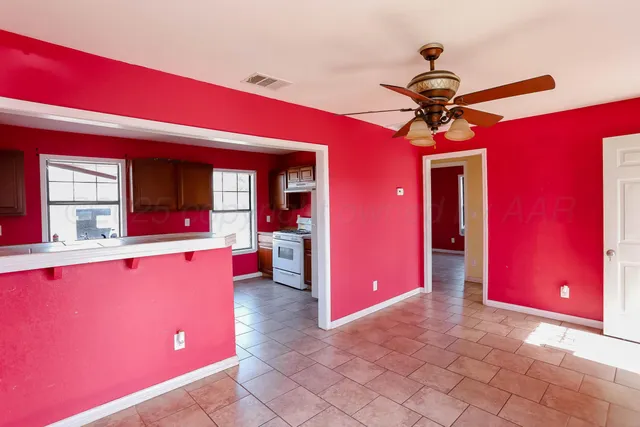 a living room with stainless steel appliances furniture a chandelier and a large window