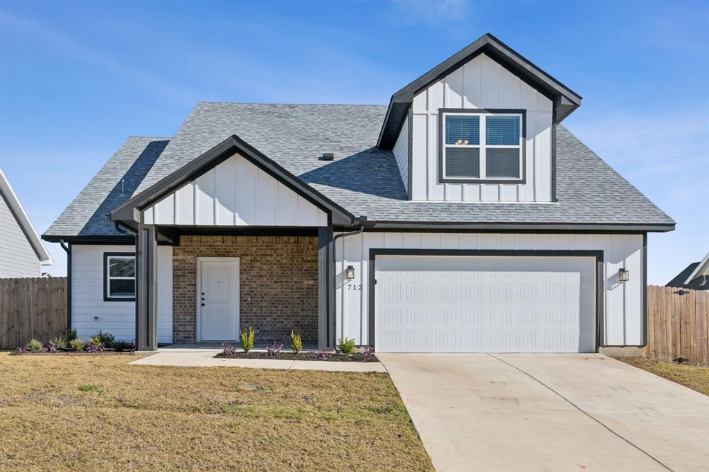 712 Taliaferro Trail Springtown, TX 76082 - Photo 1 of 1 View of front facade with a garage and a front yard