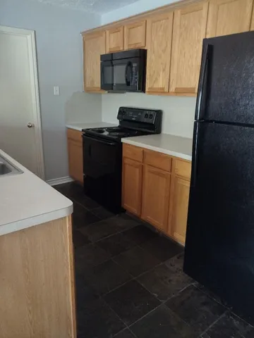 a kitchen with stainless steel appliances a refrigerator a stove a sink and white cabinets