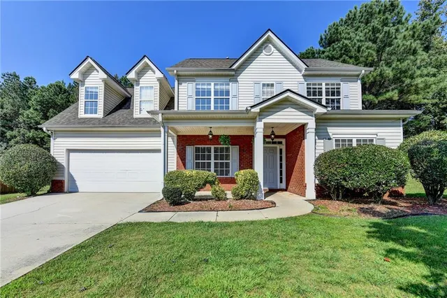 a front view of a house with a yard and garage