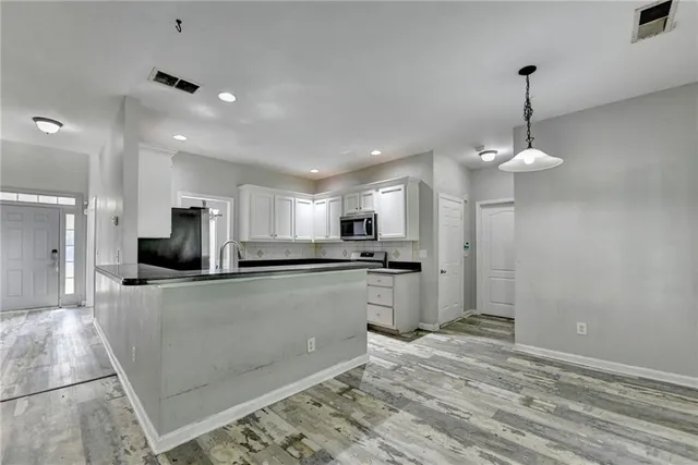 a kitchen with stainless steel appliances granite countertop a stove a refrigerator and a microwave