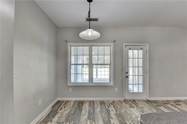 a view of a livingroom with a fireplace a ceiling fan and windows