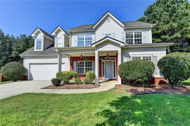 a front view of a house with a garden and plants