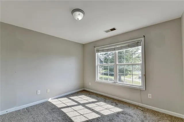 a view of an empty room and chandelier fan