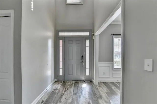 a view of an empty room with wooden floor and a bathroom