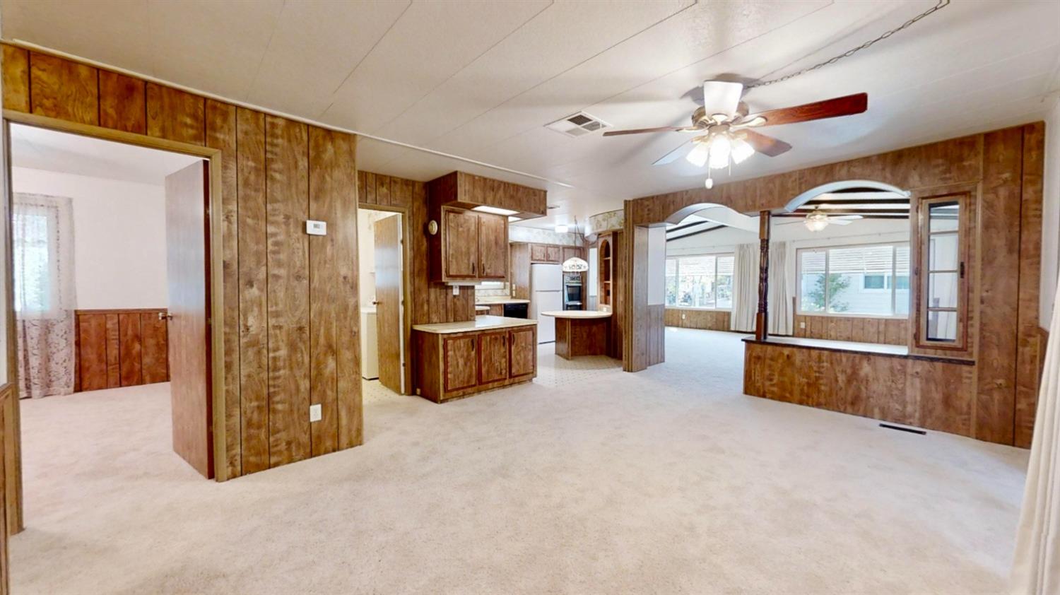 156 Rimma Way Roseville, CA 95661 - Photo 6 of 24 a view of a livingroom with furniture cabinet a flat screen tv and kitchen view