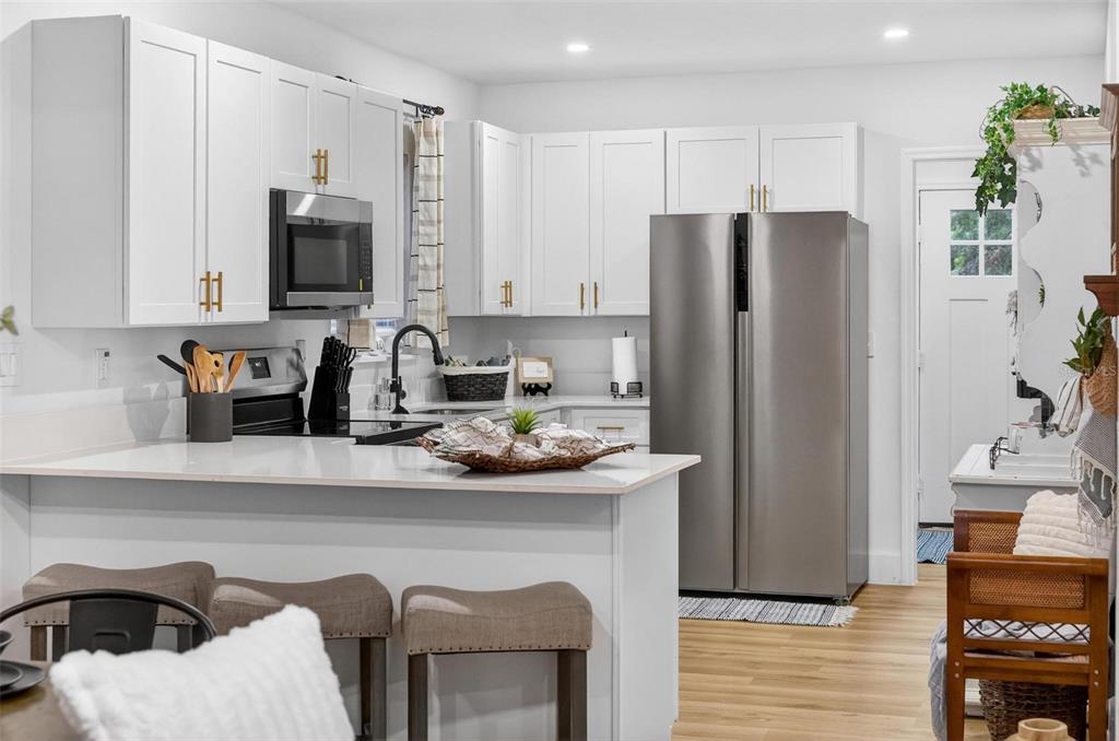 1503 Granite State Court Mount Dora, FL 32757 - Photo 26 of 77 a kitchen with stainless steel appliances a refrigerator a sink a stove a microwave a counter space and cabinets
