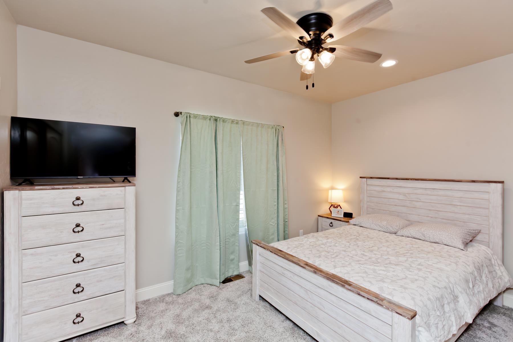 2314 Broadway Grand Junction, CO 81507 - Photo 14 of 39 a bedroom with a bed a flat screen tv and a chandelier