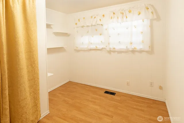 a view of a room with wooden floor and door
