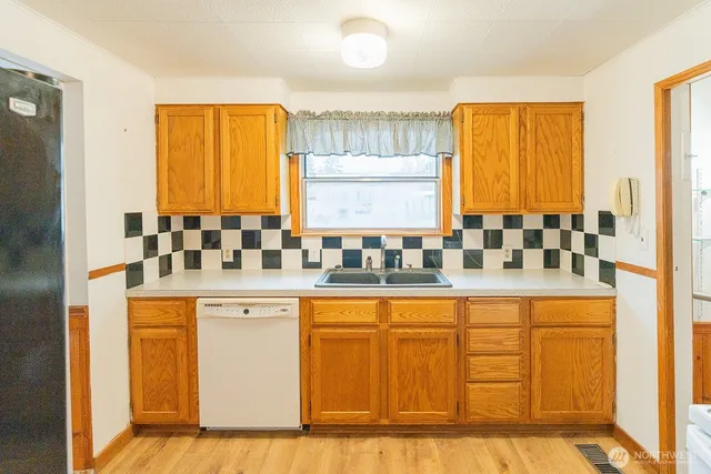 a large white kitchen with granite countertop a sink and white cabinets