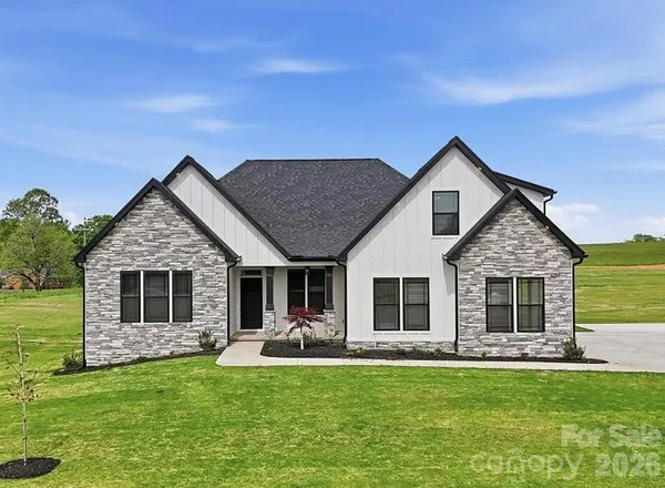 a front view of house with yard barbeque and outdoor seating